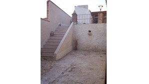 Une cour avec un escalier menant à un bâtiment. On peut y lire l’inscription « Casa Calderón I ».
