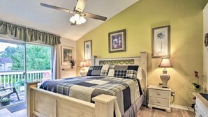 Ein Schlafzimmer mit einem Bett, Nachttischlampen, einem Beistelltisch und einem Deckenventilator.
