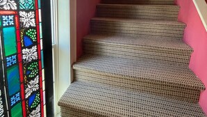 A staircase with patterned carpet leading to a landing.