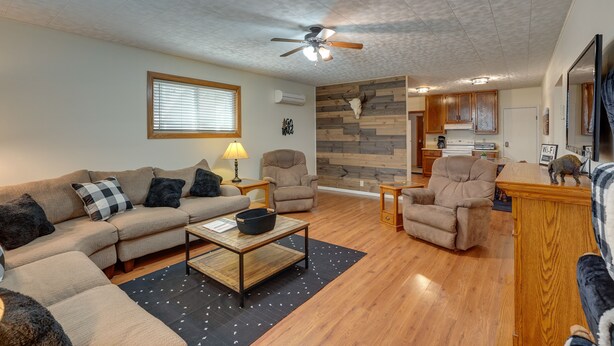 A living room with a sectional sofa, a coffee table, and a ceiling fan. - Badlands Suite of Dakota Place Lodge in Medora! (Medora)
