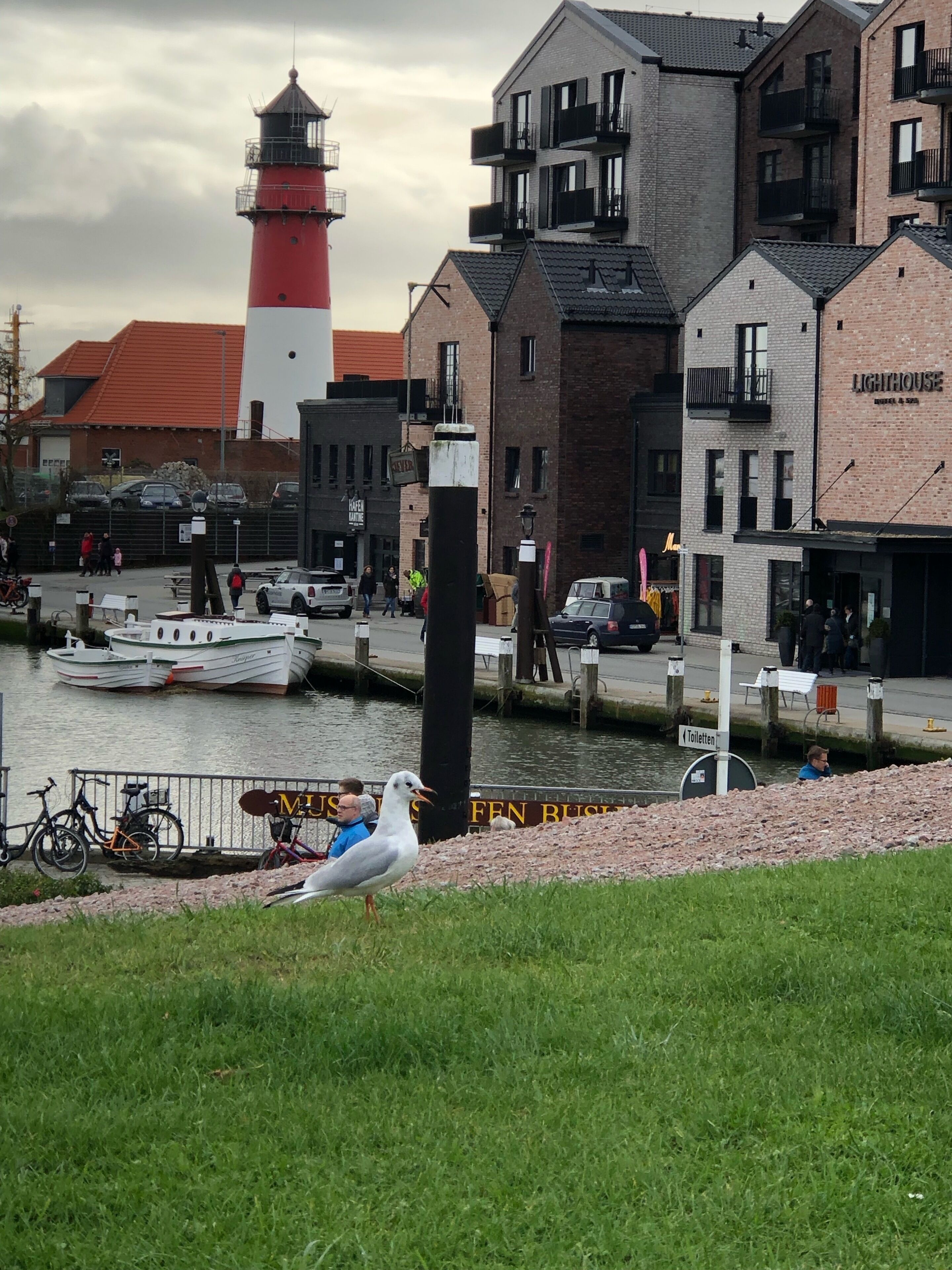 A waterfront area with a lighthouse, boats, and a building labeled 'LIGHTHOUSE.'