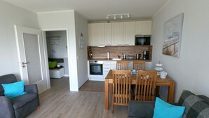A modern apartment with a living room, dining area, and kitchen.