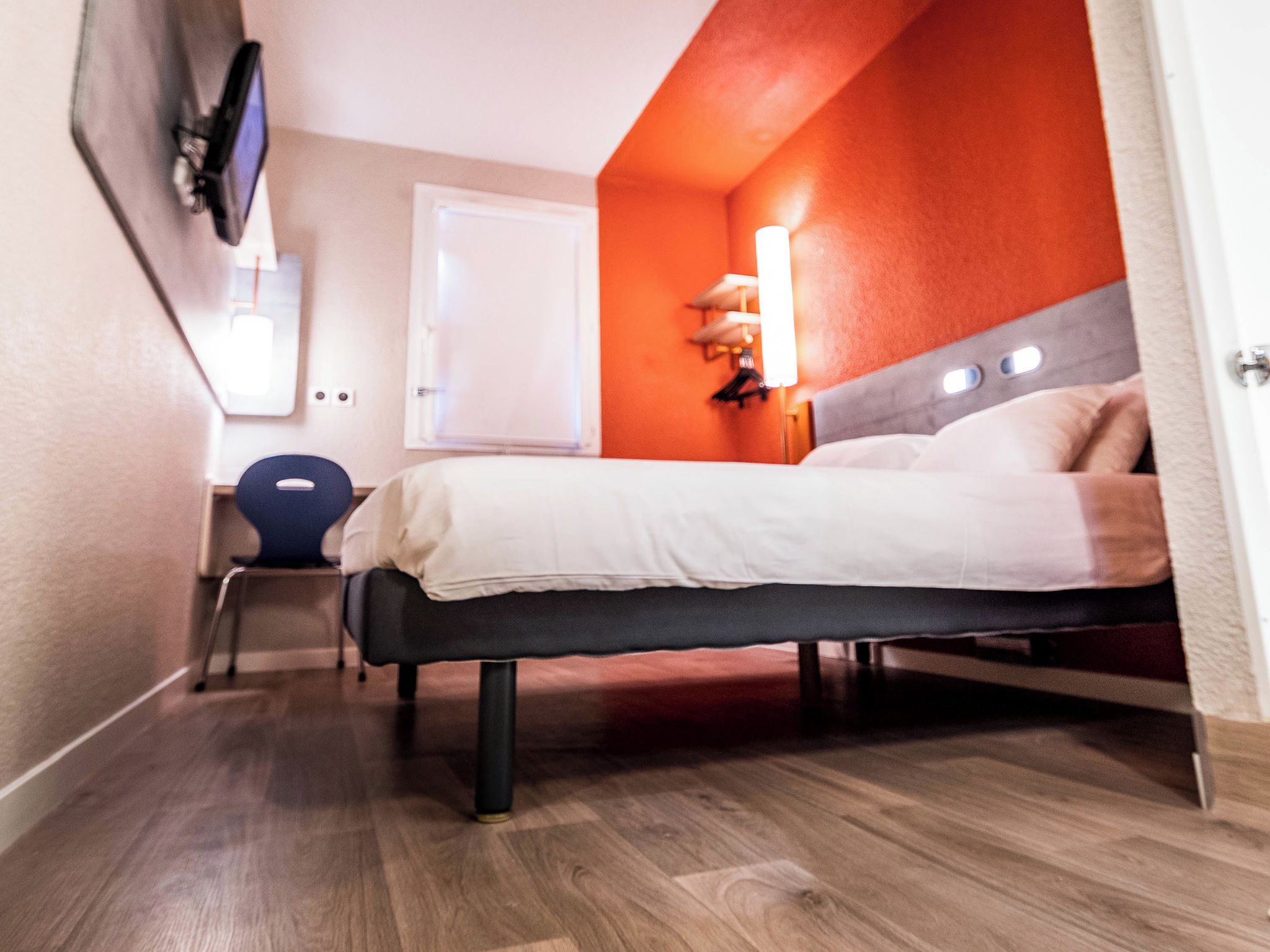 Una habitación de hotel moderna con una cama, un escritorio y una silla.