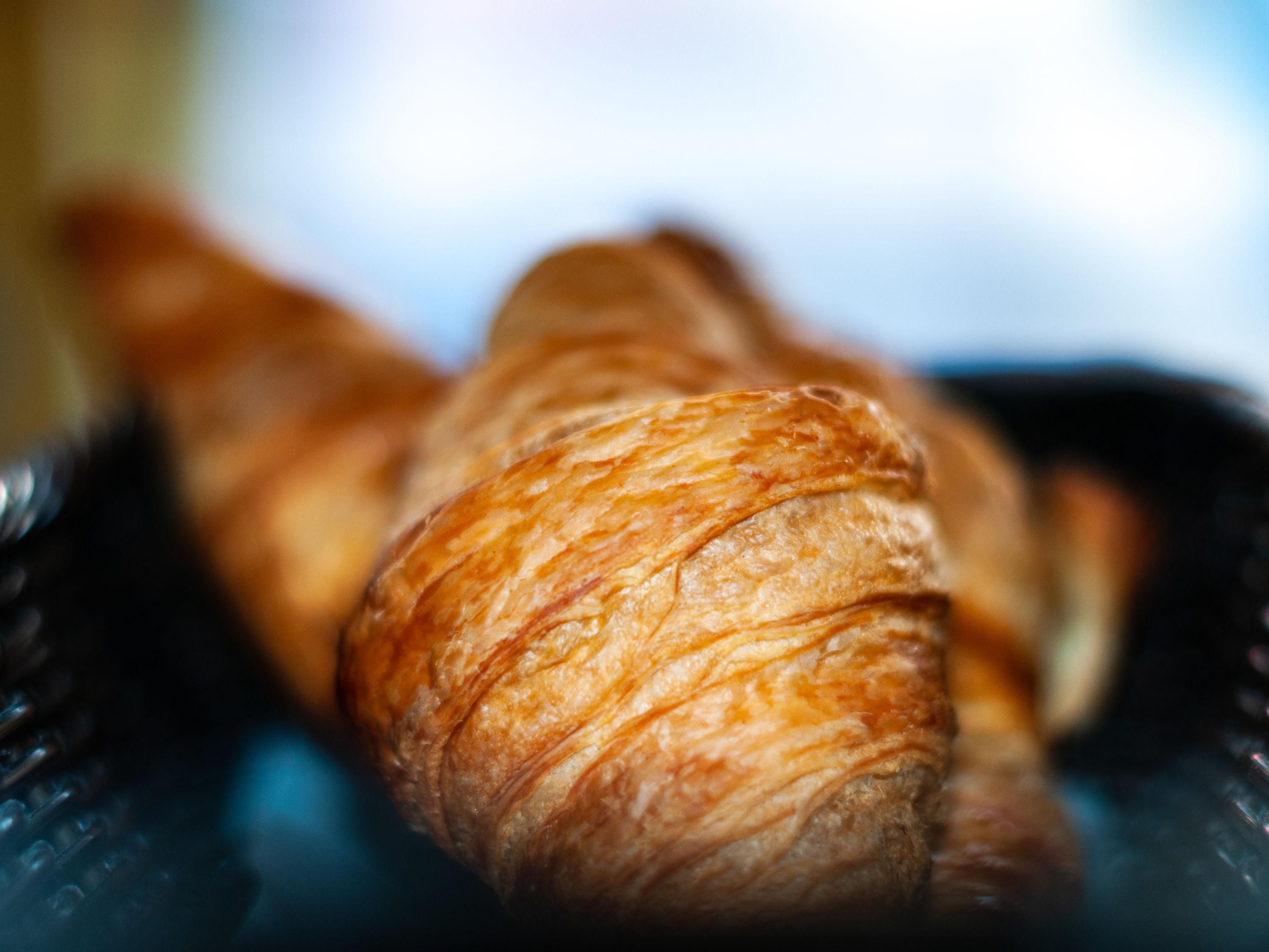 A close-up of a croissant with a flaky texture.