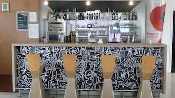 A bar area with a counter, various bottles, a microwave, and a menu board.