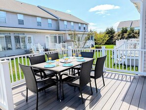 A deck with a table set for four, surrounded by white railings. - 618 (38412) Driftwood Court - Bethany Breeze (Frankford)
