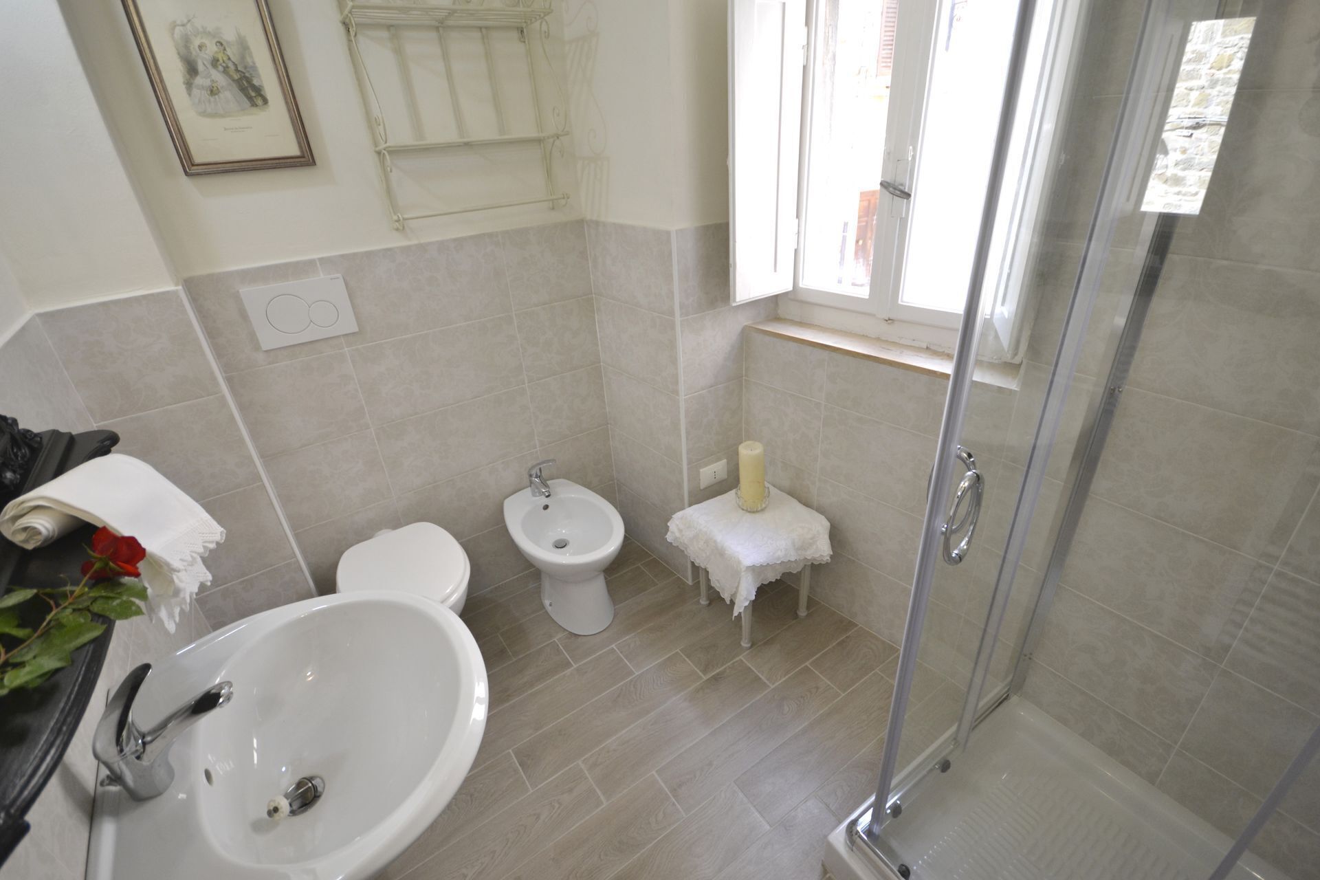 Ein Badezimmer mit Waschbecken, Toilette, Bidet und einer Duschkabine aus Glas.