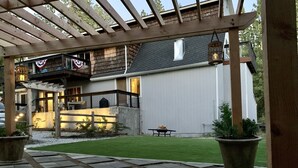 A covered patio area with a stone pathway leading to a wooden deck. - Large winter retreat just minutes from Dodge Ridge and Leland Snow Park (Mi-Wuk Village)