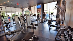 A gym with various exercise equipment, large windows, and a view of the outdoors. - Bw-1208b (Hallandale Beach)