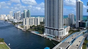 A high-rise hotel with a modern design, located near a waterfront with a marina.