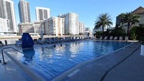 A swimming pool with lounge chairs and a cityscape in the background. - Beachwalk Resort 2007b by Optimax Vacation Rentals (Hallandale Beach)
