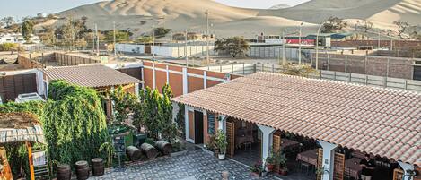 A poolside area with outdoor seating and a view of sand dunes.