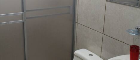 A bathroom with a toilet, sink, and shower.
