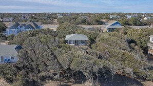 A residential area with houses, some with large trees in front. - 4752- Canopy Retreat, Walk to Beach | Quiet Kitty Hawk Retreat (Kitty Hawk)