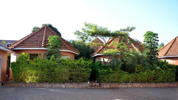 A residential area with houses featuring tiled roofs and surrounded by lush greenery. - Mak Cottages (Kampala)