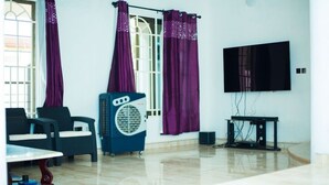 Un saló amb televisió, ventilador i dues cadires.