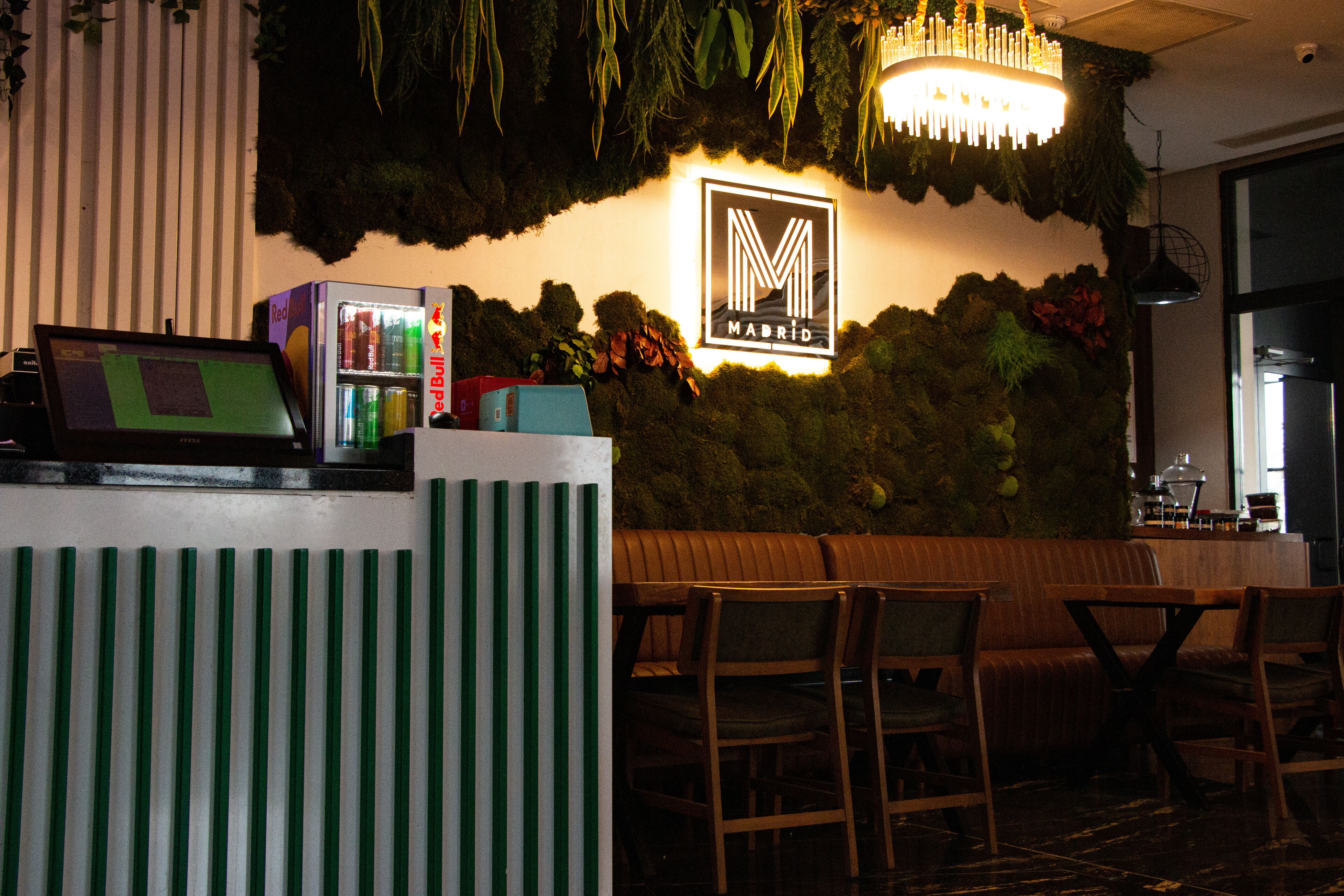 L’intérieur d’un restaurant, avec un comptoir d’accueil, un espace salon et un panneau fixé au mur.
