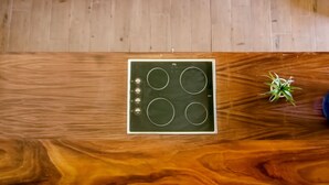 Una cucina con piano di lavoro in legno, lavello e fornello.
