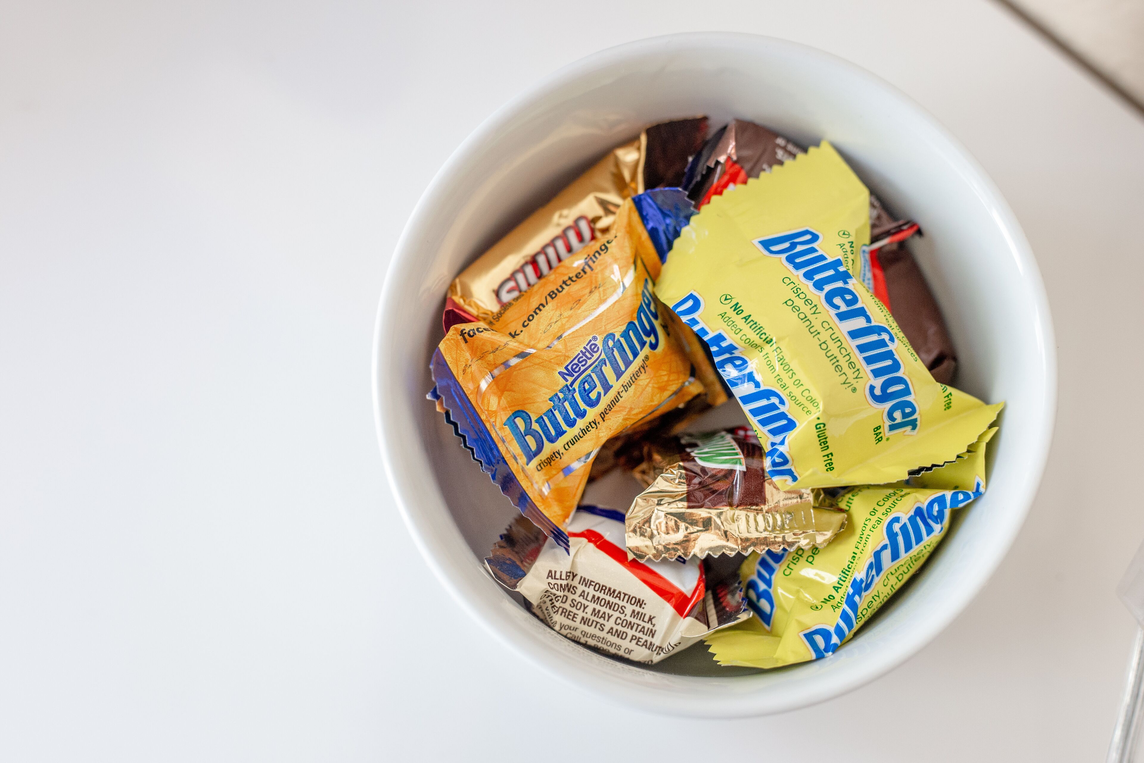 A bowl containing various packaged snacks.