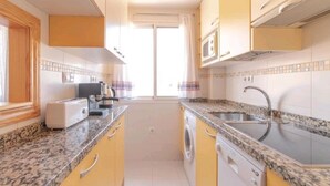 Una cucina compatta con forno a microonde, tostapane e lavatrice.