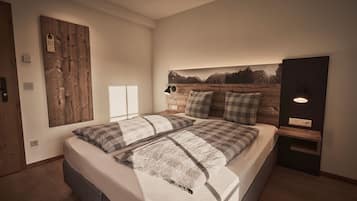 Un dormitorio con una cama grande, cabecera de madera, mesita de noche, lámpara de pared y un cuadro de montañas.