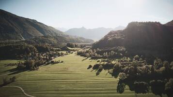 A rural landscape with rolling hills, fields, and scattered trees.