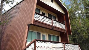 Una casa de madera de dos pisos con un balcón en el piso superior.