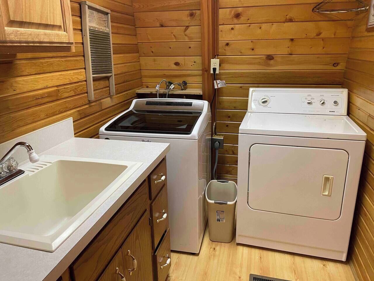A compact kitchen with a sink, a stove, and a washing machine.