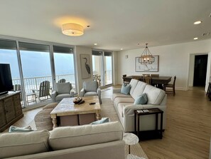 Relax in this spacious living area with a comfortable sofa set and dining area, offering a view of the ocean.
