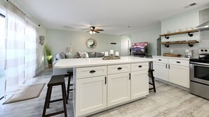 A spacious kitchen with a large island, white cabinetry, and a built-in oven.