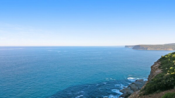 A coastal landscape with a clear view of the ocean and rocky cliffs.