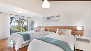 A hotel room with two beds, a large window with a view of palm trees, and a painting of a beach scene. - Amazing views and short walk to beach (Copacabana)