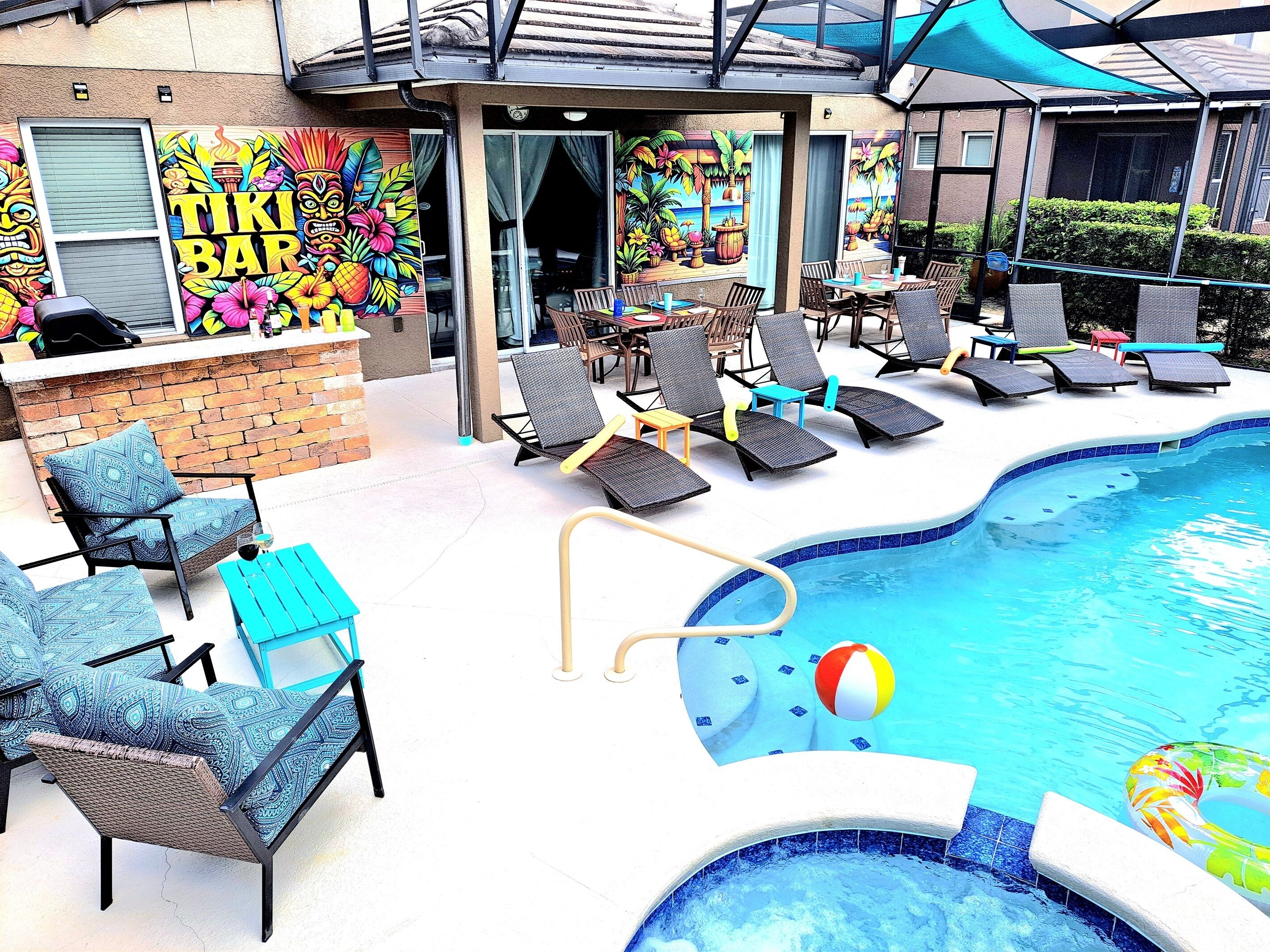 An outdoor pool area with lounge chairs, a tiki bar, and a poolside bar.