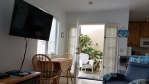 A living room with a TV, wooden furniture, a dining table, and a sofa. - Cottage By The Sea At Cayucos where serenity is found, 3 minute walk to beach (Cayucos)