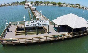 Une jetée sur laquelle est affiché un panneau indiquant : « Bienvenue à la jetée de Bradenton Beach, 1921 ».