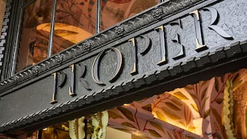 Uma placa com a palavra 'PROPER' em letras grandes e elaboradas.