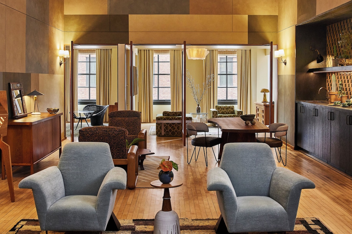 A spacious living room with a high ceiling, a dining area, and a kitchen.