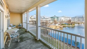 Ein Balkon mit Blick auf ein Gewässer, einen Pool und die umliegenden Gebäude.