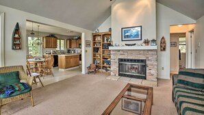 A spacious living room with a fireplace, a dining area, and a kitchen with wooden cabinets.