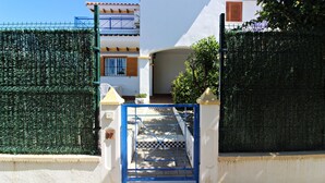 A gated entrance to a building with a checkered pathway leading to a door. - VM 6 - Duplex with private garden near the beach (Vera playa)