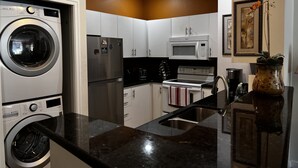A compact kitchen with a built-in washer, refrigerator, microwave, and stove. - Cozy home nearby most attractions Seattle center (Seattle)