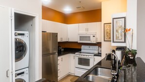 A compact kitchen with white cabinets, a stainless steel refrigerator, a microwave, and an oven. - Cozy home nearby most attractions Seattle center (Seattle)