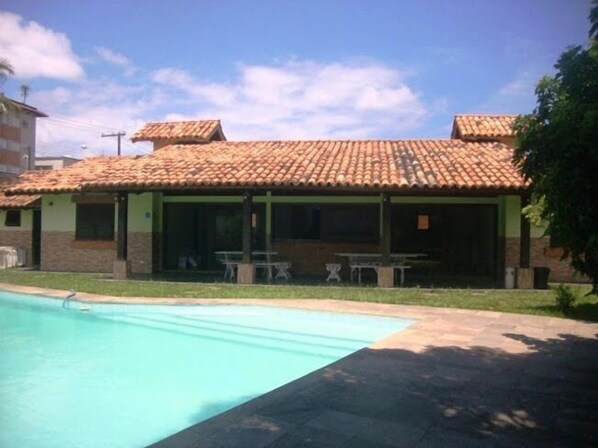 A building with a tiled roof and a swimming pool.