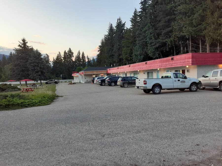 Un edificio con techo rojo y varios espacios de estacionamiento.