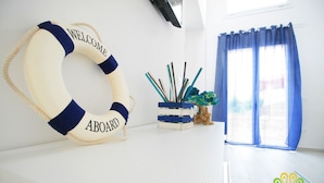A room with a life preserver on the wall, a small plant, and a window with blue curtains. - Pavon House Blue -Villetta 80 meters from the sea, 3 km from Torre San Giovanni beaches (Alliste)
