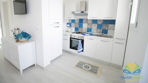 A modern kitchen with white cabinets, a built-in oven, and a gas stove. - Pavon House Blue -Villetta 80 meters from the sea, 3 km from Torre San Giovanni beaches (Alliste)
