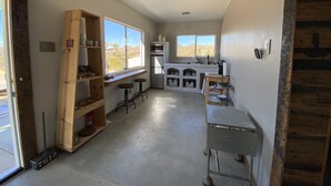 A modern kitchen with built-in appliances, large windows, and a rustic wooden beam ceiling. - Joshua Tree Monument Entrance Outside Your Front Door (Joshua Tree)
