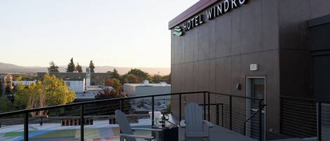 Un hotel llamado 'Hotel Windrow' con una terraza que cuenta con asientos al aire libre y una chimenea.