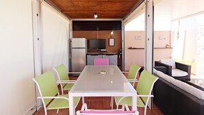 A dining area with a table and chairs, a kitchen in the background, and a balcony with seating. - Al 317 - Penthouse near the beach with terrace (Vera playa)