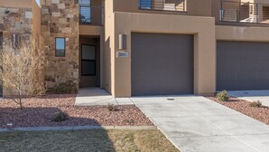 A modern two-story residential building with a stone facade, a garage, and a clear sky. - Sunny Ledgeview Retreat (St. George)